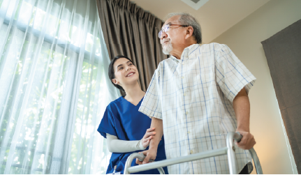 Nurse helping patient with a walker navigate through a facility